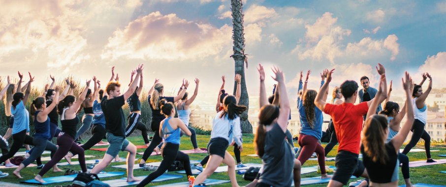 students doing yoga at the bluff during sunset